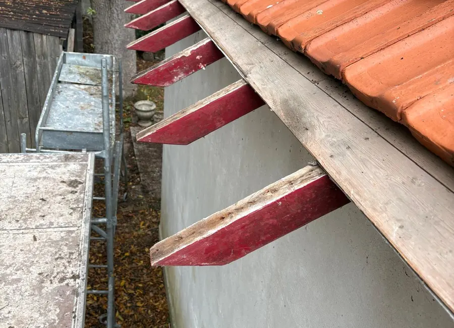 Dépose des chevrons de rive et tuiles empilées sur un chantier de rénovation