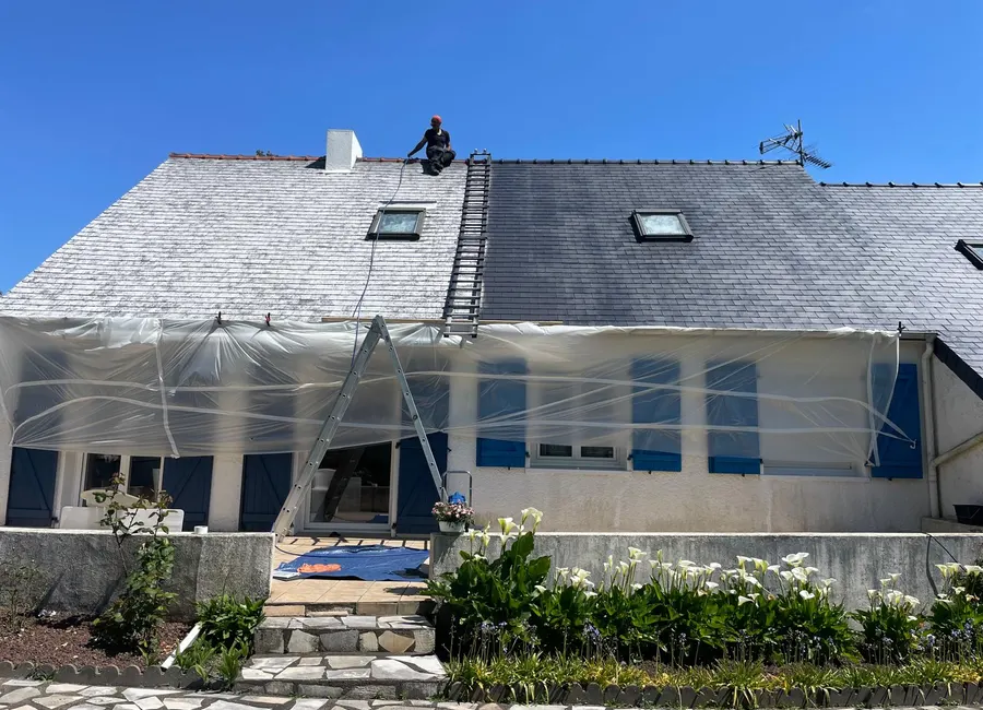 Couvreur HF Renov au faîtage pendant le démoussage d'une toiture à Nantes