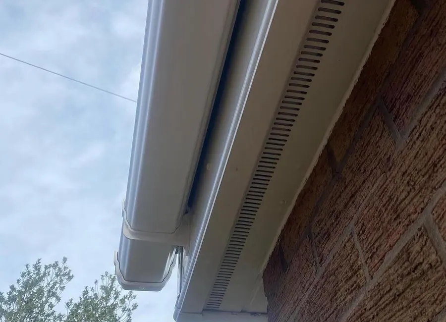 Gouttière et sous-face de toit nettoyées sur une maison en brique