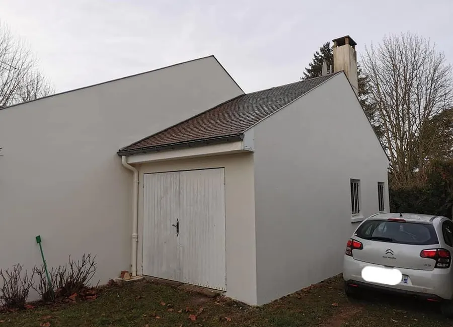 Façade de garage à l'enduit gris clair après ravalement