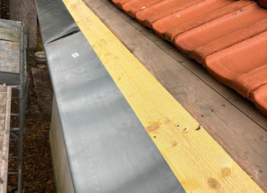 Habillage en zinc façonné sur une planche de rive